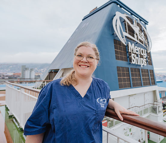 Porträtaufnahme von Dorothee Mäule vor dem Schornstein der Global Mercy.